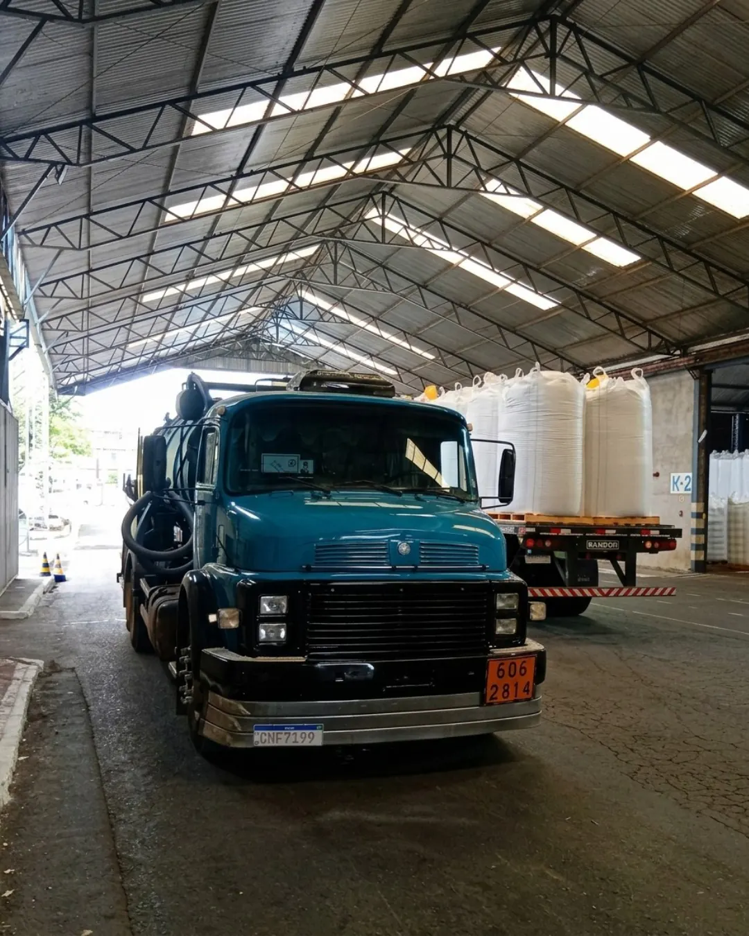 Caminhão auto vácuo azul dentro de área industrial
